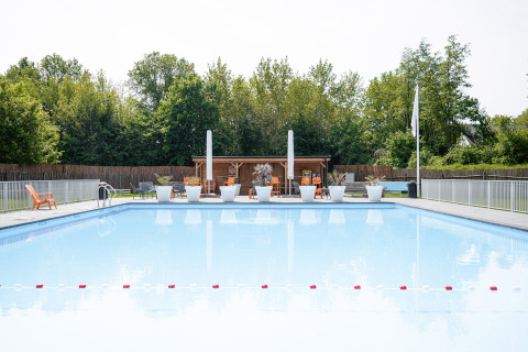 Piscina al aire libre en Camping Borken am See, Renania del Norte-Westfalia, Alemania, rodeada de árboles.