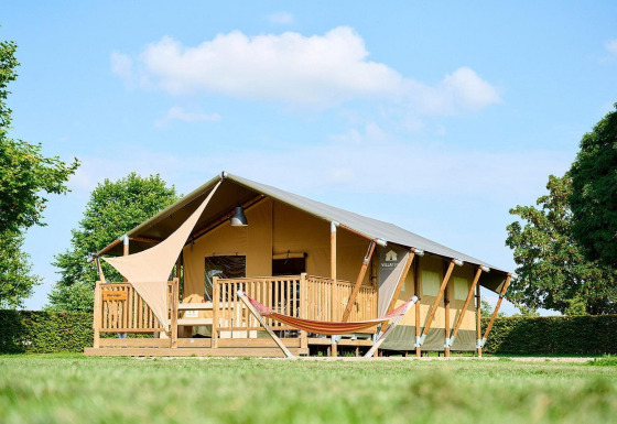 Tienda safari Villatent Nomad en Camping Betuwe, Países Bajos, con porche y hamaca en un entorno verde.