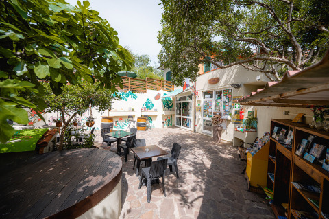 Charming outdoor patio with tables, chairs, and lush trees at Camping Casa dei Prati in Tuscany, Italy.