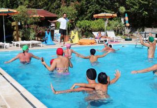 Mensen doen mee aan een water-aerobicsles in het zwembad van Camping Casa dei Prati, een vakantiepark in Toscane, Italië.