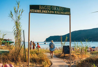 Toegang tot het strand bij Camping Casa dei Prati met zicht op zee en heuvels in Toscane, Italië.