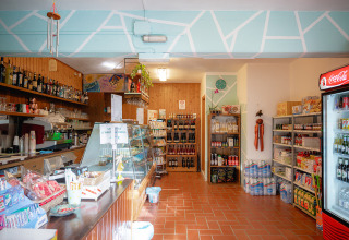 Area negozio accogliente con prodotti locali, bevande e angolo bar al Camping Casa dei Prati, Toscana.