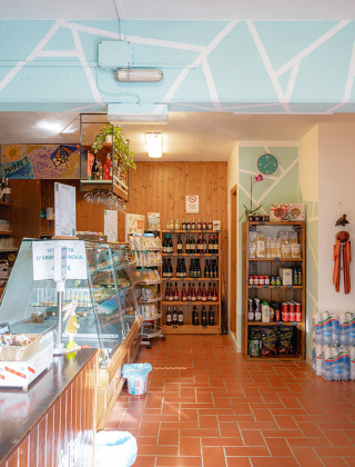 Una acogedora tienda con productos locales, bebidas y cafetería en Camping Casa dei Prati, Toscana.