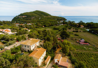 Vista aerea di Camping Casa dei Prati, villaggio turistico in Toscana, Italia, tra mare e colline verdi.
