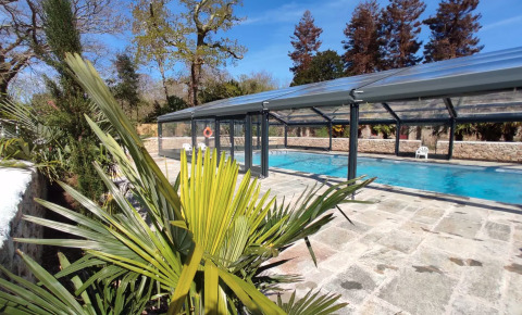 Piscina all'aperto coperta da vetro, circondata da piante a L'Orangerie de Lanniron, Bretagna, Francia.