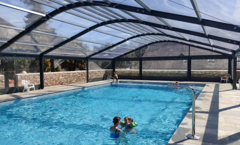 Piscina cubierta con techo transparente y huéspedes en Camping Castel L'Orangerie de Lanniron, Bretaña, Francia