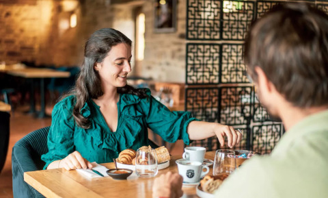 Una mujer y un hombre disfrutan de un desayuno en el Camping Castel L'Orangerie de Lanniron en Bretaña, Francia.