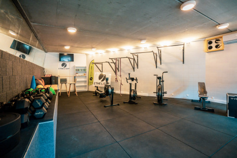Gimnasio interior con equipamiento deportivo en Camping Castel L'Orangerie de Lanniron, Bretaña, Francia.