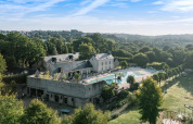 Luftfoto af Camping Castel L'Orangerie de Lanniron i Bretagne, Frankrig, med swimmingpool og grønne omgivelser.