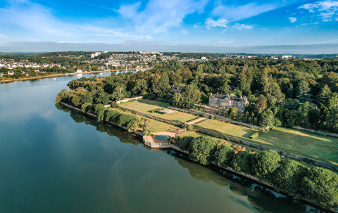 Aerial view of Camping Castel L'Orangerie de Lanniron holiday park with river and gardens in Brittany, France.