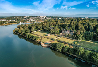 Aerial view of Camping Castel L'Orangerie de Lanniron holiday park with river and gardens in Brittany, France.
