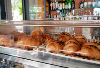 Frisch gebackene Croissants in einer Glasvitrine in einem Café im Camping Colleverde, Toskana, Italien.