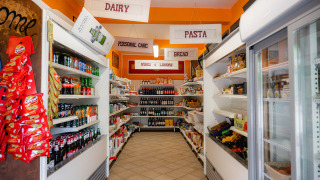 Pequeña tienda en Camping Colleverde, Toscana, con estantes llenos de alimentos y bebidas.