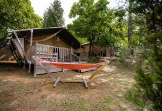 Luxury tent and hammock in the greenery at Camping Colleverde holiday park in Tuscany, Italy.
