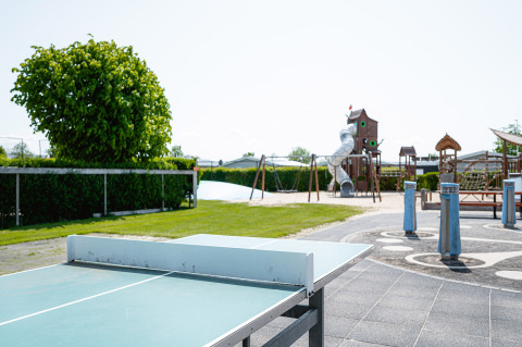 Parque infantil al aire libre y mesa de ping pong en Camping de Molenhoek, parque vacacional en Zeeland, Países Bajos.