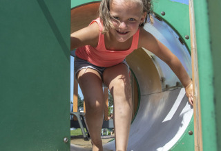 Girl playing on the playground at Camping de Molenhoek, a holiday park in Zeeland, Netherlands, on a sunny day.