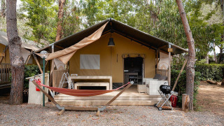 Tienda safari Villatent Nomad en Camping Casa dei Prati, Italia, con hamaca y terraza al aire libre.