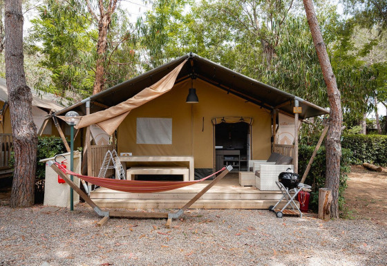 Tienda safari Villatent Nomad en Camping Casa dei Prati, Italia, con hamaca y terraza al aire libre.