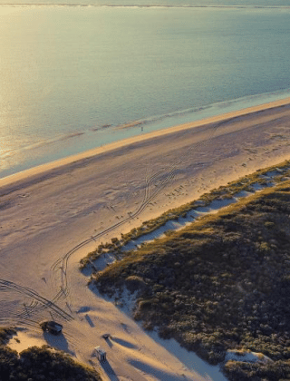Vista aérea de una playa tranquila y dunas cerca de Sommelsdijk, Holanda, al atardecer junto al mar.