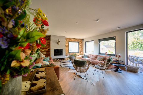 Cozy living room with modern decor, large windows and garden view at Camping de Papillon, Overijssel, Netherlands.