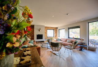 Hyggelig stue med store vinduer, moderne indretning og udsigt til terrasse ved Camping de Papillon, Overijssel.