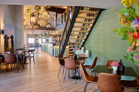 Interior moderno de cafetería en Camping de Papillon, parque vacacional en Overijssel, Países Bajos, con escalera.