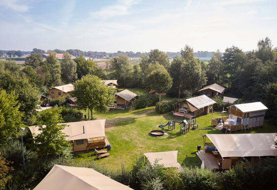 Luchtfoto van glampingtenten en speelterrein bij Camping de Papillon vakantiepark in Overijssel, Nederland.