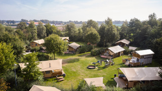 Luchtfoto van glampingtenten en een speeltuin op Camping de Papillon, een vakantiepark in Overijssel, Nederland.