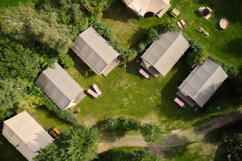 Vista aérea de cabañas y tiendas de campaña rodeadas de naturaleza en Camping de Papillon, Overijssel, Países Bajos.