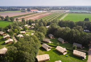 Luchtzicht op vakantiepark Camping de Papillon in Overijssel, Nederland, met tenten en landbouwvelden.