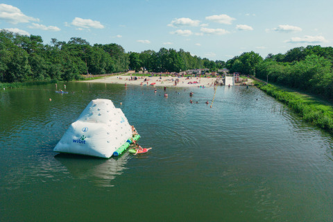 Vista aérea de lago para nadar, playa y área acuática inflable en Camping de Papillon, Overijssel, Países Bajos.