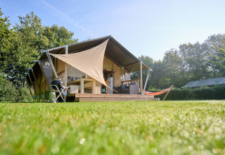 Glampingtent met terras en hangmat bij Camping de Papillon vakantiepark in Overijssel, Nederland.