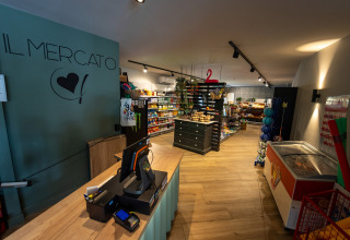 Interior of a grocery store at Camping de Papillon in Overijssel, Netherlands, with stocked shelves.
