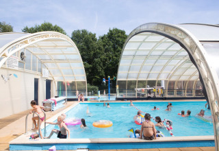 Kinderen en gezinnen genieten van een overdekt zwembad in Camping de Papillon, vakantiepark te Overijssel, Nederland.