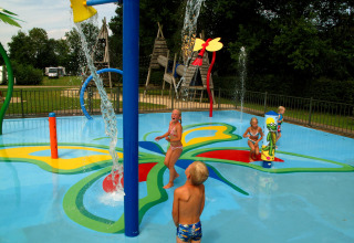 Kinderen spelen in een kleurrijke waterspeeltuin op Camping de Papillon in Overijssel, Nederland.