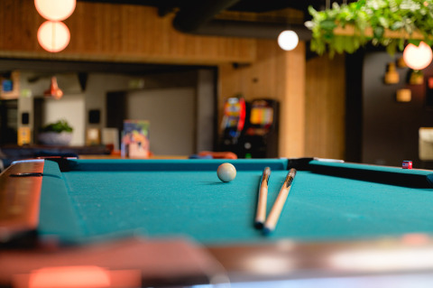 Table de billard avec deux queues et une boule au Camping de Schatberg, parc de vacances dans le Limbourg, Pays-Bas.