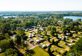 Aerial view of Camping de Schatberg holiday park in Limburg, Netherlands, with greenery and lakes.
