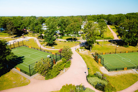 Vista aérea de Camping de Schatberg en Limburg, Países Bajos, con canchas deportivas y áreas verdes.