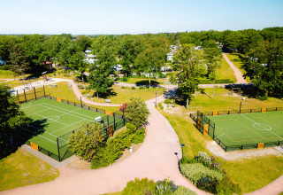 Luchtbeeld van vakantiepark Camping de Schatberg in Limburg, Nederland, met sportterreinen en natuur.