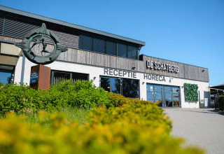 Ingresso del campeggio de Schatberg in Limburg, Paesi Bassi, con insegne di reception e horeca visibili.