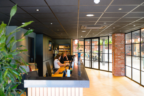 Reception area with staff working at Camping de Schatberg, a holiday park in Limburg, Netherlands.