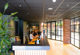 Reception area with staff working at Camping de Schatberg, a holiday park in Limburg, Netherlands.