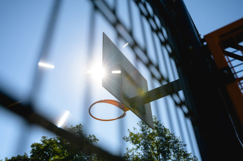 Sunlight shines through a basketball hoop and backboard at Camping de Schatberg, Limburg, Netherlands.