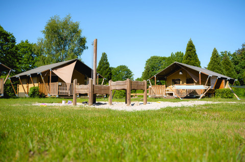 Two glamping tents and a sand playground at Camping de Schatberg holiday park in Limburg, Netherlands.