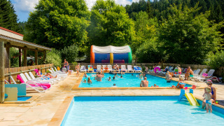 Piscine extérieure au Camping de Vaubarlet, Auvergne-Rhône-Alpes, France, avec familles profitant du soleil.