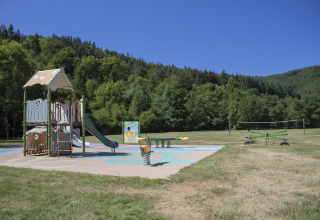 Speelplein bij Camping de Vaubarlet met glijbaan en groen uitzicht in Auvergne-Rhône-Alpes, Frankrijk.