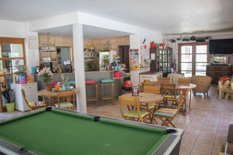 Pooltafel en gezellig cafézitgedeelte met bar bij Camping de Vaubarlet, Auvergne-Rhône-Alpes, Frankrijk.
