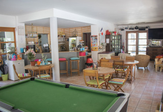 Pooltafel en gezellig cafézitgedeelte met bar bij Camping de Vaubarlet, Auvergne-Rhône-Alpes, Frankrijk.