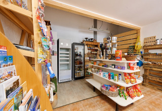 Kleine winkel met rekken vol snacks en producten op Camping de Vaubarlet, Auvergne-Rhône-Alpes, Frankrijk.