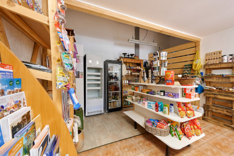 Tienda pequeña con estantes de alimentos y bebidas en Camping de Vaubarlet, Auvernia-Ródano-Alpes, Francia.